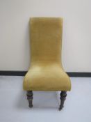 An antique nursing chair upholstered in a gold dralon