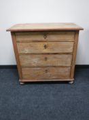 A 19th century pine four drawer chest on bun feet