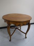A circular oak table on cabriole legs