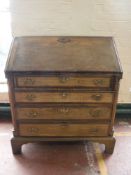 An oak bureau fitted four drawers on bracket feet