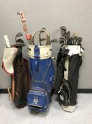 Three golf bags of assorted irons,