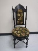 A carved ebonised hall chair in a floral tapestry fabric