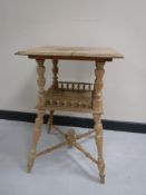An early 20th century stripped oak two tier occasional table