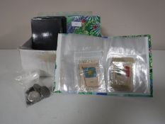 A box containing albums of cigarette silks together with a bag containing assorted British coins