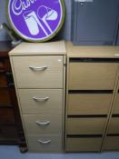 Two wooden four drawer filing cabinets with keys