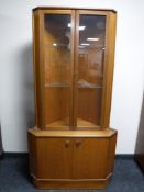 A teak corner display cabinet