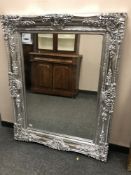 An ornate silvered overmantel mirror,