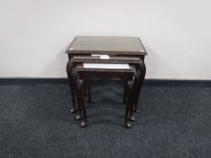 A nest of three glass topped tables