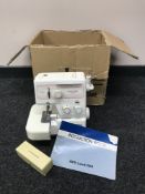 A boxed New Home by Janome over locking sewing machine