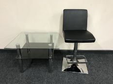 A contemporary glass and chrome two tier coffee table and gas lift bar stool