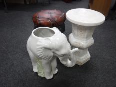 An elephant planter with plant stand and a wrought iron footstool