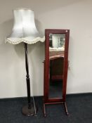 A standard lamp with shade and a mirrored cheval jewellery cabinet
