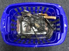 A basket containing assorted metal ware, including companion set, trivet, cutlery, carving set,