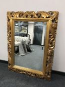 A gilded ornate bevelled wall mirror,
