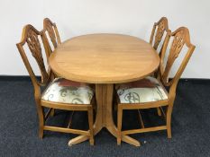 A Nathan oval extending teak table and four shield back chairs