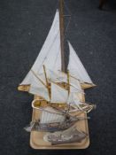 A tray containing four wooden model yachts on stands