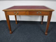 An early 20th century mahogany writing table inset leather panel