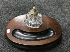 An Edwardian oak inkstand with glass ink well
