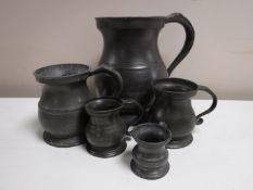 A set of five graduated antique pewter tankards