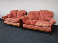 A pair of mahogany and bergere framed two seater settees upholstered in a pink fabric