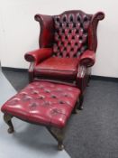 A red button leather wing back Chesterfield armchair with stool CONDITION REPORT: