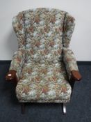 A tapestry upholstered wing back rocking chair