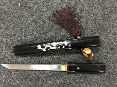 A Japanese knife in a lacquered sheath