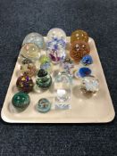 A tray of sixteen assorted glass paperweights