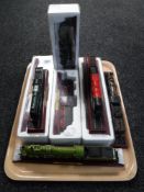 A tray of eight model trains on plinths