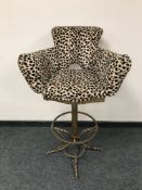 A contemporary bar stool upholstered in leopard print