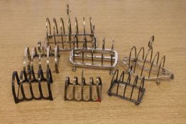 Seven antique silver toast racks