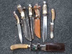 Seven assorted horn handled knives in sheaths