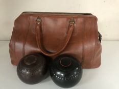 A leather bag containing two sets of lawn bowls