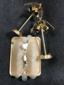 A pair of brass ceiling lights with glass shades