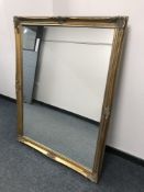 A bevelled overmantel mirror in ornate gilded frame,