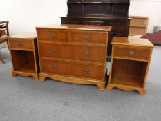 An inlaid yew wood four drawer chest and pair of bedside stands