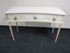A shaped cream and gilt hall table on reeded legs