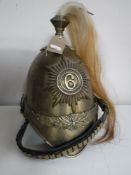 A reproduction brass cavalry helmet with horse hair plume