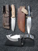 Three hunting knives in sheaths