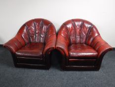 A pair of red leather club armchairs
