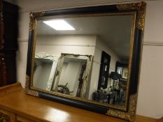 An ebonised and gilded overmantel mirror,