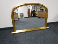 A gilt framed arched overmantel mirror