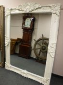 A large Victorian style white painted bevelled mirror,
