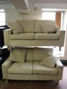 A pair of two seater settees in cream fabric with scatter cushions