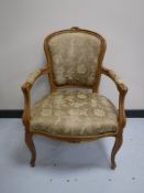 A carved salon armchair in gold brocade