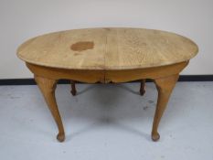 An early 20th century oval oak dining table and six blonde oak chairs