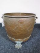 An antique copper coal bucket on paw feet