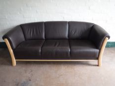 A beech framed brown leather three seater settee