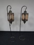 A pair of ornate metal candle holders on stands