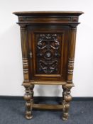 A late 19th century oak hall cupboard with carved panel door